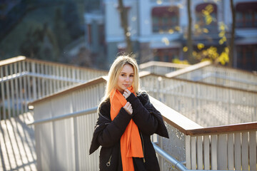 girl in black clothes with an orange scarf on the background of the city