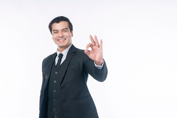Agreement, winner, business successful concept. Confident smile handsome businessman wear suit using finger make sign ok for good idea or job while standing over isolated white background. Focus hand.