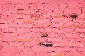 Old dirty worn weathered brick stone wall with traces of pink paint texture background surface