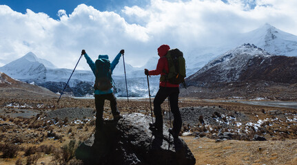 Two women hikers hiking in winter high altitude mountains