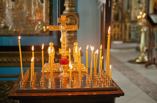 burning candles in church with a golden cross religious background. Inside a church. Russian othodox church.