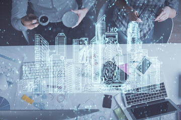 Double exposure of man and woman working together and the buildings hologram drawing. Computer background. Top View. Smart city concept.