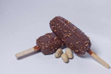 two chocolate ice cream with peanut crumbles isolated on a white background