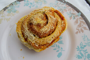Fresh homemade baked goods. Hot bun (snail) on a plate