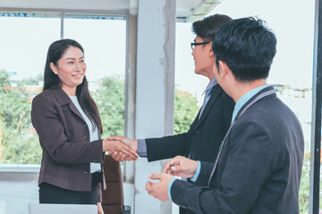 Business team and business partners handshake together to agree joint business and partnership.