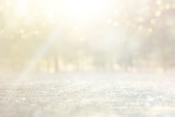 blurred abstract photo of light burst among trees and glitter golden bokeh lights