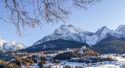 Ftan, Switzerland - December 03. 2021: Panorama of Swiss Tarasp village with Tarasp Castle in early winter season viewed from Ftan Baraigla hillside