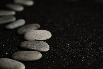 small sea pebbles are laid out on a black background
