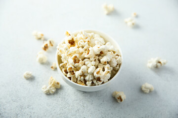 Homemade salted popcorn in a white bowl