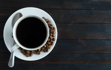 Top view, a cup of espresso coffee with coffee beans on a wooden background. copyspace