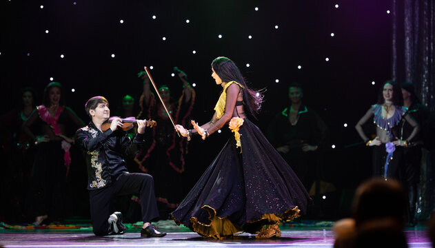 A team of musicians, singers and dancers in gypsy costumes singing and dancing on stage