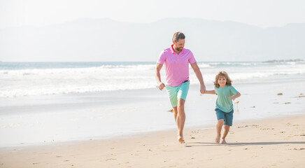 family of cheerful daddy man and child boy running on beach, activity