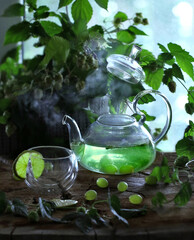 Atmospheric photo of a teapot and a mug with green tea on a wooden table
