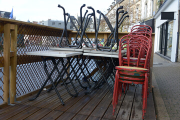 Chaises et tables attachées d'une terrasse d'un restaurant fermé à Vannes en Bretagne