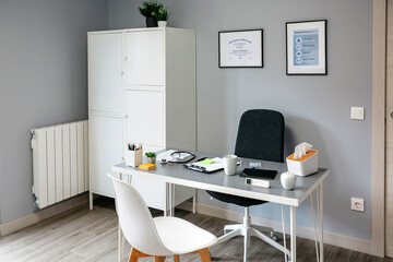 Interior of empty doctor's office with table and cupboard