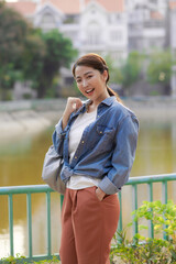 Confident young female student in formal clothes outfit walking in the city park,