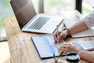 Close-up of businesswoman analyzing chart and graph showing changes on the market.
