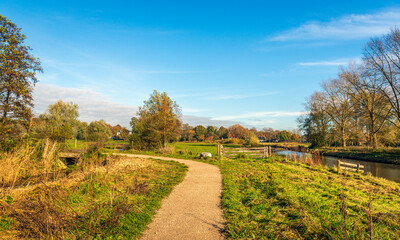 Picturesque Dutch landscape with a curved path in the Markdal nature reserve near the city of Breda, province of North Brabant. The photo was taken at the beginning of a sunny day in the autumn season