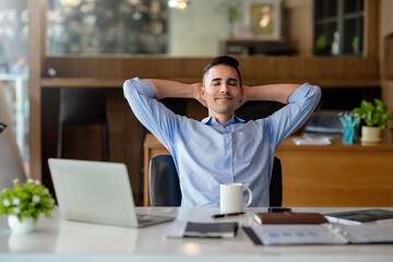Businessman enjoy and happy of relaxing at the office. Hold hands behind head concept of success...