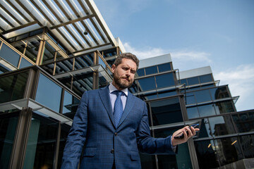 frustrated entrepreneur in businesslike suit hold phone outside the office, bankruptcy