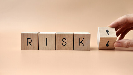 Wooden cubes with the inscription: risk and up and down arrows. Reducing or increasing business...