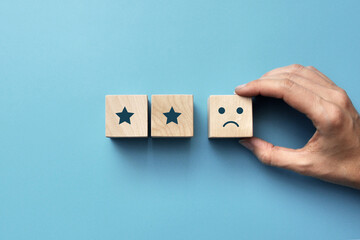 Wooden cubes with drawings of two stars. A symbol of bad reviews and low rating. Two stars