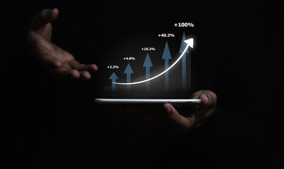 Business man holding tablet and showing holographic graphs and stock market statistics gain profits. Concept of growth planning and business strategy.