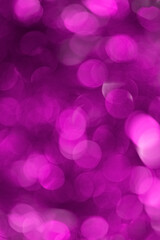 Blurred purple background with defocused bokeh circles from a Christmas garland vertical orientation