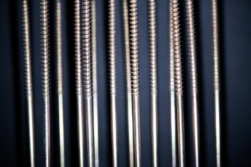 group of metal wood screws lined up isolated on black background in close up