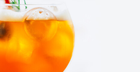 Close up glass of ice cold Aperol spritz cocktail served in a wine glass on a white background.