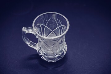 small oriental style glass tea cup with engraving isolated on dark background