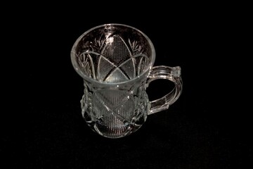 small oriental style glass tea cup with engraving isolated on dark background