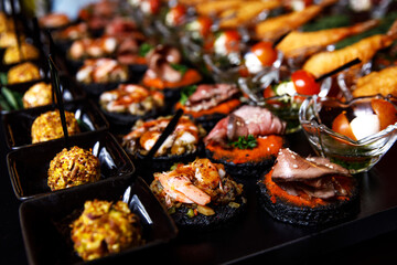 Banquet Meat Bar. Cold snacks with vegetables, fish and rucola on bread, canapes