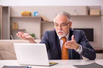 Old male employee working from home during pandemic