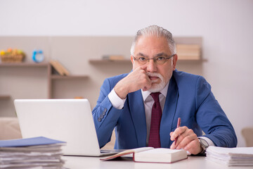 Fototapeta premium Old male employee working from home during pandemic