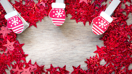 Creative Christmas background with red sequins in the shape of stars on a wooden background with copy space.