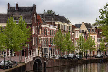 Fototapeta premium Beautiful and quaint street view with old buildings and greenery in spring in Leiden, Netherlands