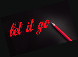 Let it go words written with a yellow pencil on black. Forgiveness, future planning and new life beginning concept