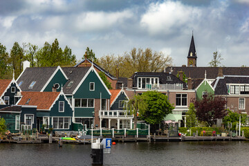 Beautiful small houses by the water with windmills in Zaanse Schans, Netherlands