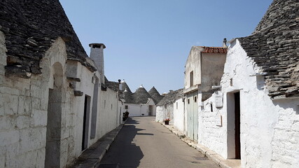 Fototapeta na wymiar Alberobello is a city in Puglia, Italy. It is known for the Trulli, white conical stone buildings, present by the hundreds in the hilly district of Rione Monti.