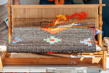 spinning cotton thread with a wooden retro craftsman spinner machine. Culture and tradition concept