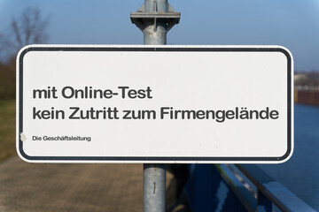 Schild am Eingang zu einem Firmengelände in Deutschland mit der Aufschrift: mit Online Test kein...