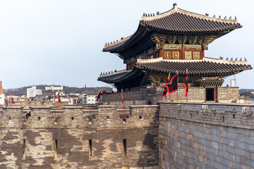 Hwaseong is a fortress of the Joseon Dynasty that surrounds the center and white coulds with blue sky background. At Suwon City, South Korea.