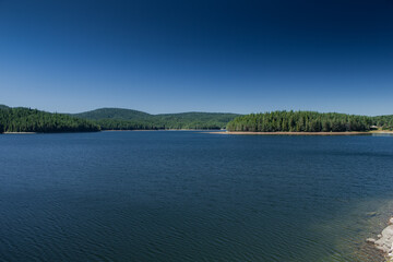 Lake with deep blue sky and water in clear summer day with greenery