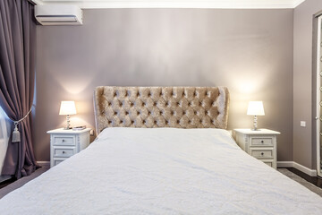 luxury hotel bedroom. Bed with carriage coupler headboard