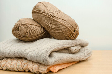 Fototapeta na wymiar Skeins of beige yarn. DIY knitted sweater.