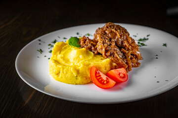 Fried liver with onion and mashed potatoes on white plate