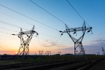 In the evening, the silhouette of high voltage towers