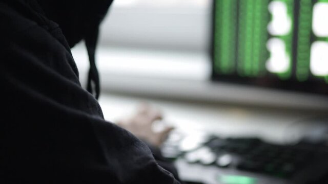 hacker in mask at computer,cyberattacks world servers,steals data,hacks security firewall