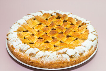 Tradition american apple pie with sugar crust on violet pink background